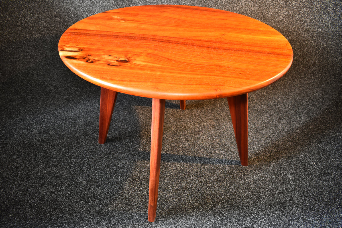 Runt vardagsrumsbord i exklusivt Padauk-trä med vinklade ben och tidlös skandinavisk design.