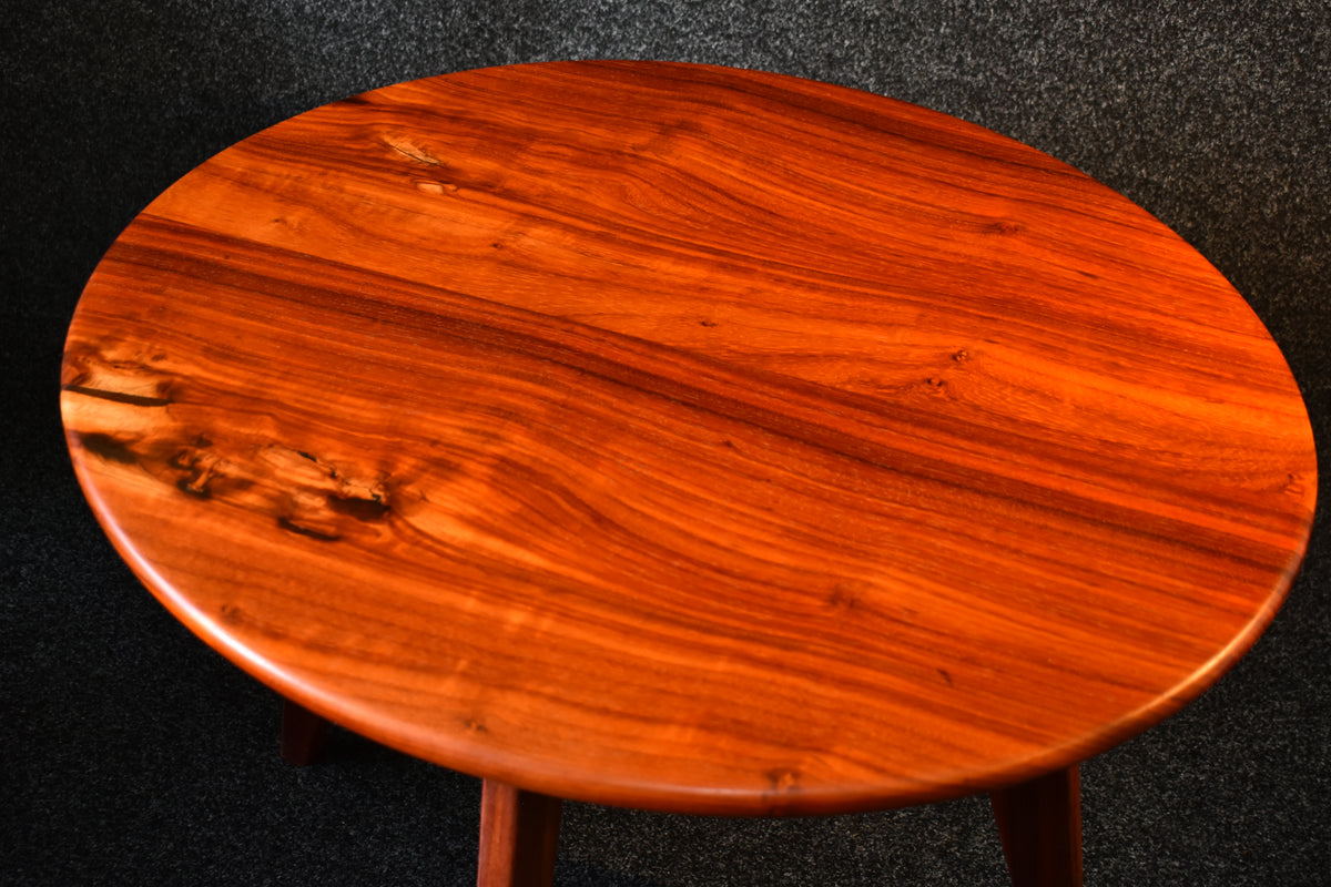 Närbild på den exklusiva bordsytan i Padauk som framhäver träets naturliga lyster och finish.