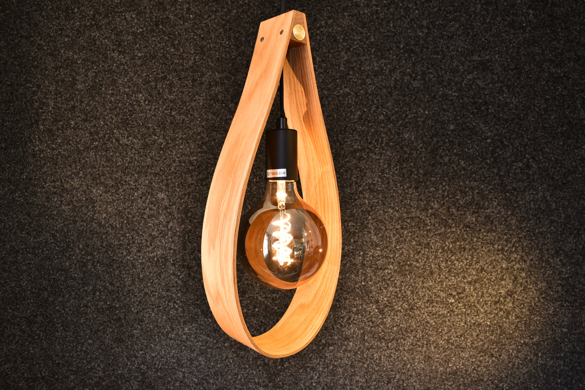 Stor taklampa i massiv ek med dekorativ glödlampa som skapar ett varmt och inbjudande sken.