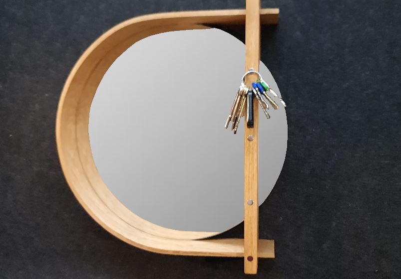 Närbild på hallspegelns smarta magnetiska funktion som håller nycklar på plats i den massiva eken.
