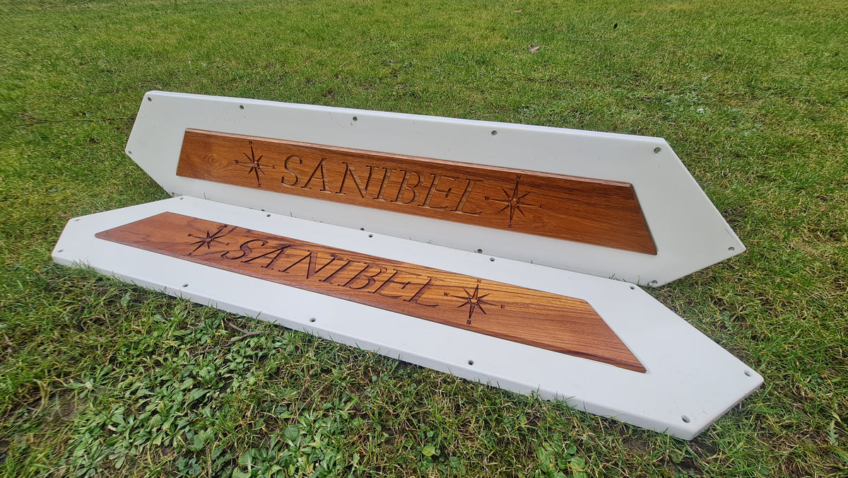 Närbild på personlig 3D-gravyr och logotyp på en exklusiv båtskylt i ädelträ teak.